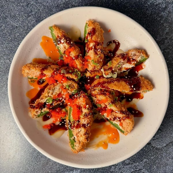 Banzai Sushi's fried jalapeño poppers, drizzled with sauce, topped with tobiko and sesame seeds.